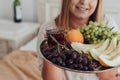 Unrecognisable Young Woman Holding Tray of Fruit in Hotel Room, Bottle of Wine Stands on the Background Royalty Free Stock Photo