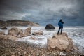 Unrecognised person standing at the rock and enjoying the stormy seascape