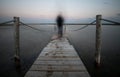 Unrecognised person walking like a ghost at a wooden pier