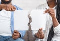 African american couple holding torn piece of paper