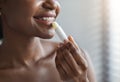 Unrecognizable african american woman applying hygienic lip balm