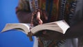 Unrecognizable African black man in traditional dress with rosary reading the Holy Bible Royalty Free Stock Photo