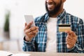 Unrecognizable African Man Holding Credit Card And Phone Indoors, Cropped Royalty Free Stock Photo