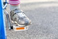 Unrecognizable anonymous child`s foot resting on a bicycle pedal, object closeup, little young kid cyclist riding a bike Royalty Free Stock Photo