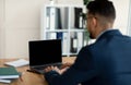 Unrecognizable Arab entrepreneur working on laptop pc with blank screen at office, mockup for website design