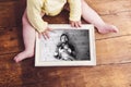 Unrecognizable baby holding family photo. Fathers day. Royalty Free Stock Photo