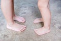 Unrecognizable barefoot children with dirty feet standing on concrete floor/poverty concept Royalty Free Stock Photo