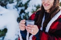 unrecognizable beautiful young woman at sunset in snowy mountain pouring hot tea from thermos to metallic cup. Travel and Nature Royalty Free Stock Photo