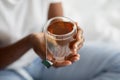 Unrecognizable black woman in pajams holding mug with tea