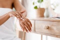 Unrecognizable Black Woman In White Bath Towel Applying Body Milk On Hands Royalty Free Stock Photo