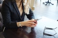 Unrecognizable blonde business woman in suit with phone sitting at a table in a cafe Royalty Free Stock Photo