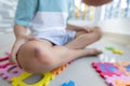 Unrecognizable boy is sitting on rubber baby mat with broken knee. Medical care for children.