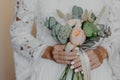 Unrecognizable Bride with tender manicure, holds beautiful bouquet, wears white wedding dress. Special occasion, ceremony concept Royalty Free Stock Photo
