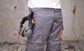 Unrecognizable builder with hearing protection hanging from the trousers