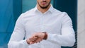 Unrecognizable business man boss leader manager wears white formal shirt looks at wrist watch angry of late time Royalty Free Stock Photo