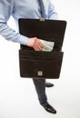 Unrecognizable businessman puts money in a briefcase Royalty Free Stock Photo