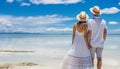 Unrecognizable couple enjoying a sunny beach day with clear waters and gentle ocean breeze