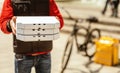 Unrecognizable Courier Offering Pizza Boxes Standing Near Scooter Outside, Cropped