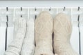 Cropped cozy cute pair of child, adult frozen feet in wool, knitted socks warming up near gas or electric heat radiator