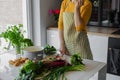 Unrecognizable cropped woman in striped apron choose vegetable to chop and slice. Rustic organic food for loosing weight