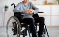 Unrecognizable disabled teen boy in wheelchair using cellphone, browsing web or posting in social media at home Royalty Free Stock Photo