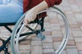Close up of a young woman in a wheelchair while walking in a park on a sunny day. Recovery and healthcare concepts