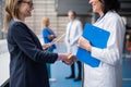 Doctor talking to pharmaceutical sales representative, shaking hands. Royalty Free Stock Photo