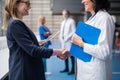 Doctor talking to pharmaceutical sales representative, shaking hands.