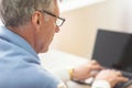 Unrecognizable Elderly Man Using Laptop Sitting Indoor