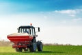 Agricultural tractor fertilizing wheat crop field with NPK Royalty Free Stock Photo
