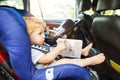 Unrecognizable father with little children sitting in the car.