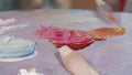 Unrecognizable female artist mixing paint on a palette