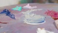 Unrecognizable female artist mixing paint on a palette