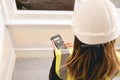 Unrecognizable female civil engineer with long blond hair calculating with a calculator in a construction site, yellow Royalty Free Stock Photo