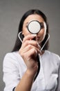 Unrecognizable female doctor showing stethoscope to camera.