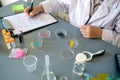 Unrecognizable female scientist examining glitter samples in petri dishes on laboratory Royalty Free Stock Photo