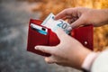 Unrecognizable female takes out 20 euro banknote from a red leather wallet on the street. Payment, salary and banking Royalty Free Stock Photo