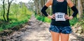 Unrecognizable female trail athlete posing with race number