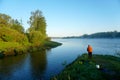 Unrecognizable fisherman by the river, rear view, Fog on the river early in the morning