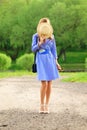 Unrecognizable girl in cornflower blue dress covers her face with a straw hat Royalty Free Stock Photo