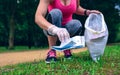 Girl picking up trash doing plogging Royalty Free Stock Photo