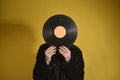 unrecognizable girl face covered with vynil record