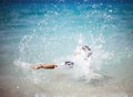 Unrecognizable girl splashing in crystal clear blue sea water. Royalty Free Stock Photo