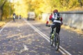 Unrecognizable guy, back to us riding bike in autumn park, bright colorful trees, sunny day, fall foliage. Healthy Royalty Free Stock Photo