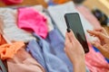 Unrecognizable hand woman packing suitcase, check things on the smartphone