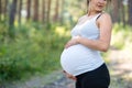 Unrecognizable pregnant woman outdoors in nature, touching her belly. Royalty Free Stock Photo