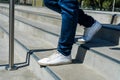Unrecognizable latino man with a jean and white sneakers going down a cement stairs. Horizontal orientation Royalty Free Stock Photo