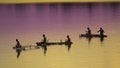 Unrecognizable local fishermen fishing in small wooden boats at colorful sunrise Royalty Free Stock Photo