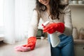 Unrecognizable maid in rubber gloves cleaning countertop at kitchen interior, hands with detergent and rag Royalty Free Stock Photo