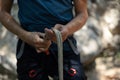 Unrecognizable male climber preparing for climbing by tying the knot